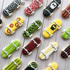 many decorated cookies are arranged in rows on a white table with wooden boards behind them