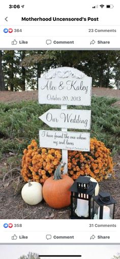 a sign that is sitting in the grass with pumpkins and candles on it, next to some flowers