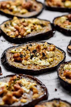 baked stuffed eggplant sitting on top of a baking sheet covered in cheese and other toppings