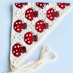 a crocheted triangle with red and white polka dots on it