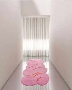 a pink rug in the middle of a white room