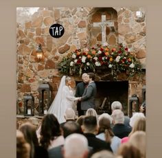 a couple getting married in front of a stone fireplace