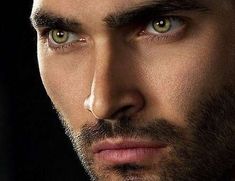 a close up of a man with green eyes