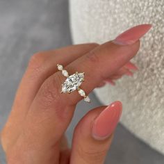 a woman's hand with a ring on her finger and a diamond in the middle