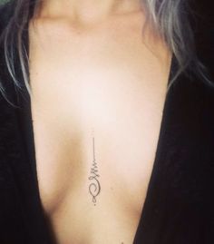 a woman's chest with a small tattoo on it