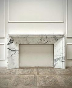 an empty room with marble fireplace and white walls