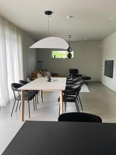 a dining room table with chairs and lights hanging from the ceiling