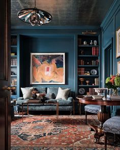 a living room with blue walls and rugs on the floor is featured in an instagram