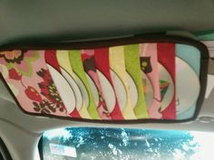 the rear view mirror is decorated with plates and flowers on pink, green, yellow and white strips