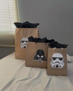 three bags with star wars stickers on them sitting on a white table cloth covered bed