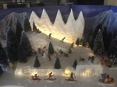 a display case filled with toy figurines of people skiing and snowboarding in the woods