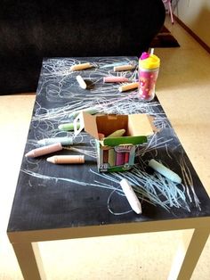 the table is covered with chalk and crayons for art project on it's side