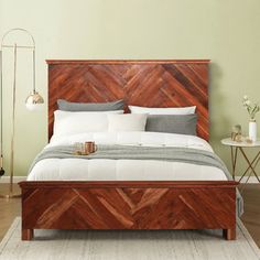 a bed with wooden headboard and foot board in a green room next to a white rug