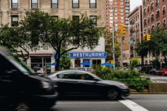 a car is driving down the street in front of a restaurant