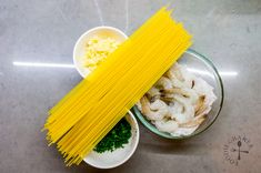 pasta, shrimp and parsley in small bowls on a counter top with seasoning