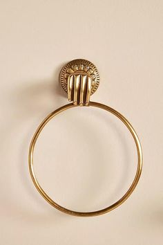 an antique gold towel ring on a white wall