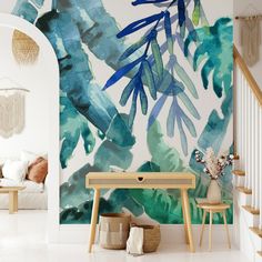 a living room with white walls and blue leaves on the wall, along with two wooden stools