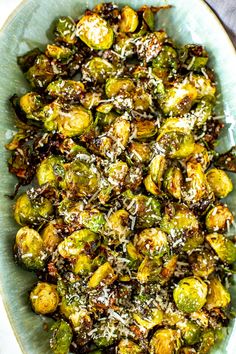 brussel sprouts with parmesan cheese on top in a bowl