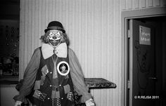 a man dressed as a clown holding a bag