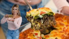 a woman holding a slice of pizza in front of her face