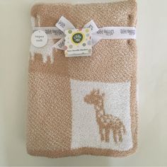 a brown and white towel with giraffes on it's side next to a tag