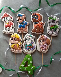 a number four decorated cookies with cartoon dogs on them