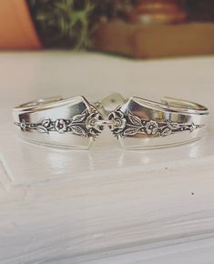 two silver rings sitting on top of a table