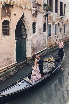 a man and woman kissing in a gondola on the canals of venice, italy