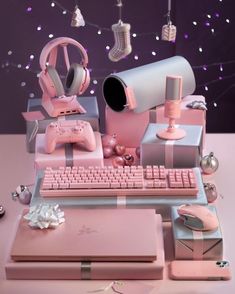 there is a pink computer set up on the desk with headphones and other accessories