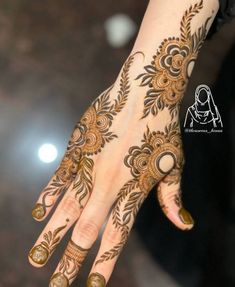 a woman's hand with henna tattoos on it