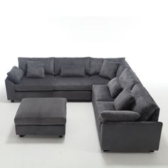 a large sectional couch and ottoman with pillows on the bottom, sitting in front of a white background