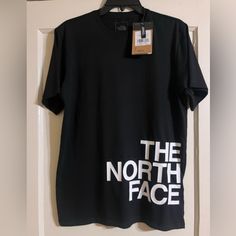 New Black North Face Short Sleeve Shirt. 100% Cotton Size Small. Standard Fit. The North Face On The Front With The Emblem On The Back. The North Face Black Tops With Letter Print, Black The North Face Tops With Letter Print, The North Face Relaxed Fit Top For Streetwear, The North Face Cotton Graphic Tee, The North Face Letter Print Streetwear Tops, The North Face Black Crew Neck T-shirt, Black The North Face Crew Neck T-shirt, The North Face Graphic Print Tops For Streetwear, Black Crew Neck T-shirt By The North Face