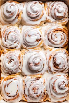 a pan filled with cinnamon rolls covered in icing