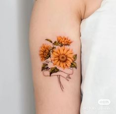 a sunflower tattoo on the left arm and shoulder is shown in this close up photo