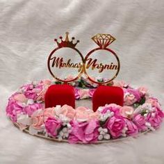 two red chairs sitting in front of a pink and white flower wreath with the words mr and mrs written on it