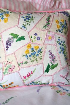 a close up of a pillow on a bed with flowers and stripes in the background