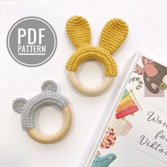 two crocheted bunny ears and a wooden ring on top of a book