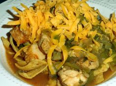 a white plate topped with chicken and green beans covered in grated cheddar cheese