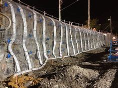 construction workers are working on the side of a fence