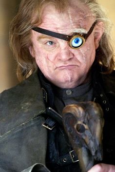 a man with an eye patch on his forehead holding a bird in front of him