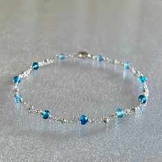 Super dainty mixed blue topaz gemstone beaded handmade bracelet in sterling silver This very thin and minimal bracelet is designed with genuine, 3.5 mm, sky blue topaz, london blue topaz and swiss blue topaz rondelles, evenly spaced along segments of double strand sterling silver chain and completed with a sterling silver lobster claw clasp.  These premium-quality gemstones are micro-faceted, highly polished, and quite sparkly.  Topaz is the birthstone for December. This skinny and dainty and bracelet is perfect for layering or worn by itself.  It is enlarged to show details.  Details: bracelet length: please choose at check-out faceted mixed blue topaz:  3.5 mm  sterling silver chain, clasp and other components Thanks for visiting ! Back to my shop for more jewelry options: www.etsy.com/s Topaz Bracelet, Minimal Bracelet, Blue Topaz Bracelet, Bracelet Minimalist, Bracelet Blue, Bracelet Ideas, Minimalist Bracelet, Swiss Blue Topaz, Blue Jewelry