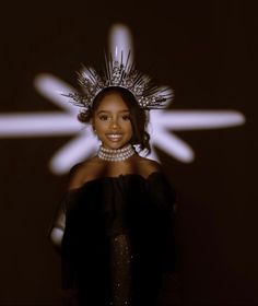 a woman in a black dress with a crown on her head