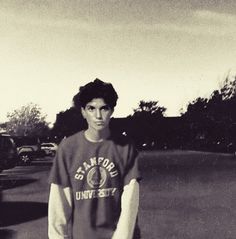 a young man standing in the middle of a parking lot