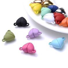 several different colors of plastic teapots on a white plate