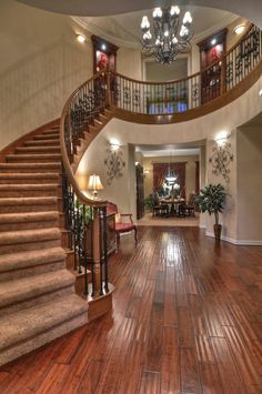 a large foyer with wooden floors and chandelier