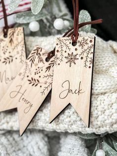 three wooden tags with the words happy christmas and snowflakes hanging from them on a string