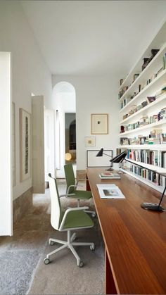 an office with bookshelves, desk and chairs in the middle of the room