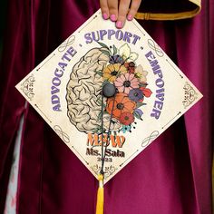 a woman in a purple graduation gown holding up a sign that says support for memory