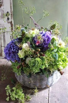 a basket filled with purple and green flowers