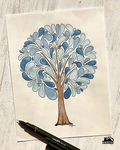 a drawing of a tree with blue leaves on it, next to a black marker